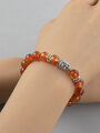 Elegantní náramek z 0,8 cm velkých korálků karneolu s kovovými ozdobami a korálek s hlavičkou Buddhy