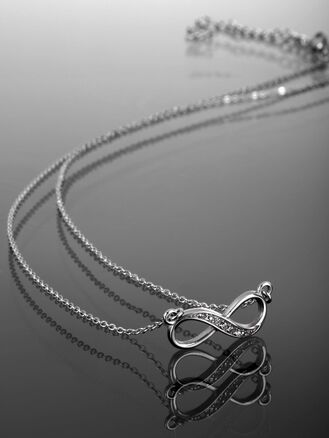 Nádherný ocelový náhrdelník s přívěskem  ve tvaru nekonečna, vykládaný čirými krystaly