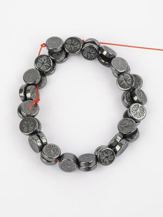 Korálková šňůra z kovově lesklých placiček hematitu s motivem strom života, rozměry cca 8 x 2 mm